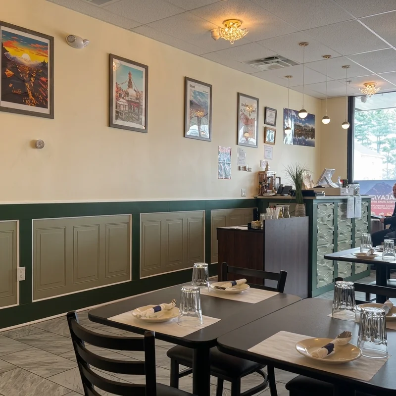 The dining room, a row of travel posters under crystal chandeliers