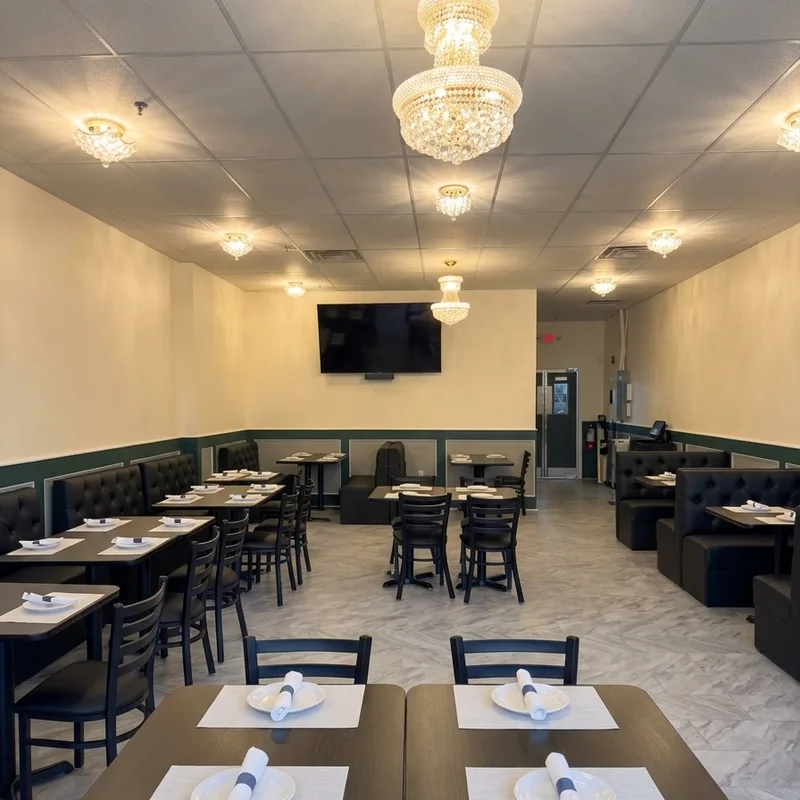 The dining room set for service, tables and booths under crystal chandeliers
