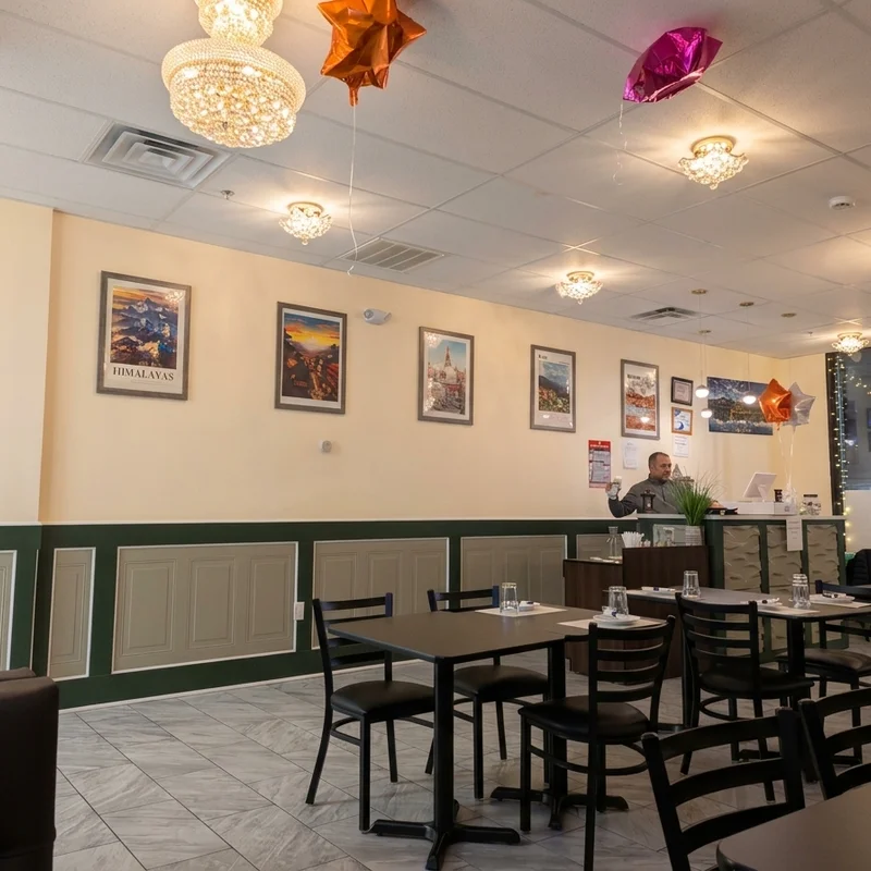 The dining room, travel posters along the wall under chandeliers